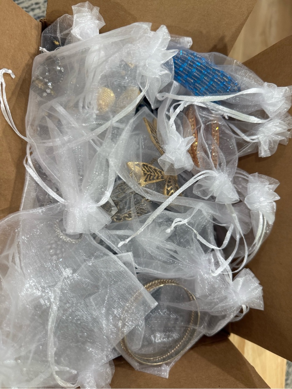 Box of Fashion Jewelry Packaged in Sheer Drawstring Pouches